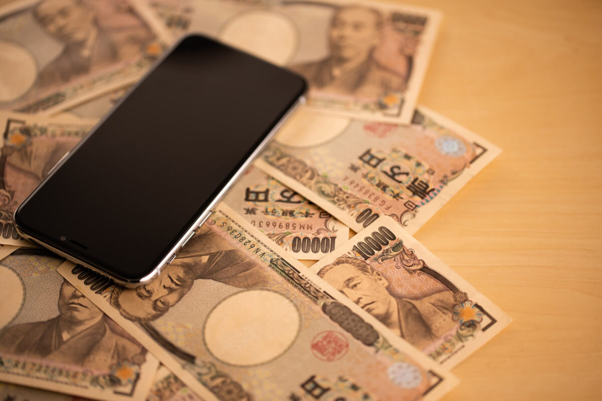 スマホと複数枚の1万円札